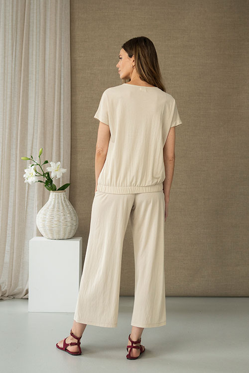Blusa fluida beige con escote en pico y bajo elástico