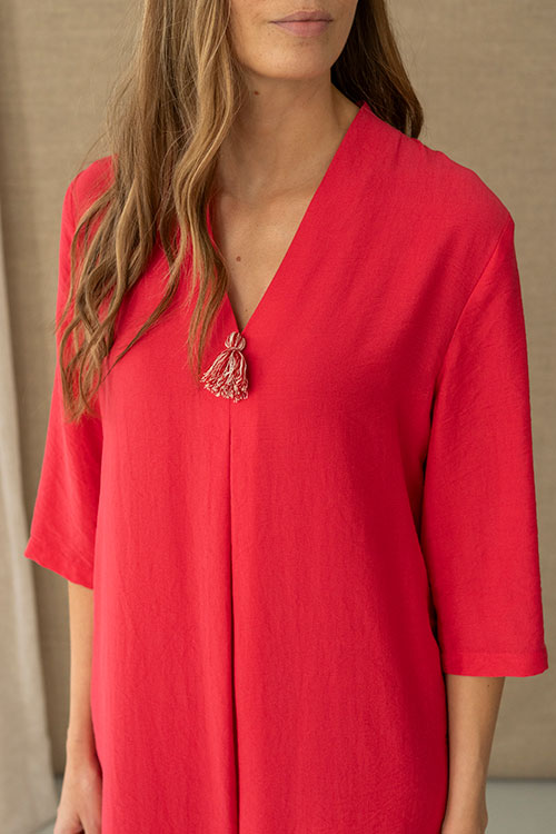 Vestido fluido color fresa con escote en pico y borla decorativa